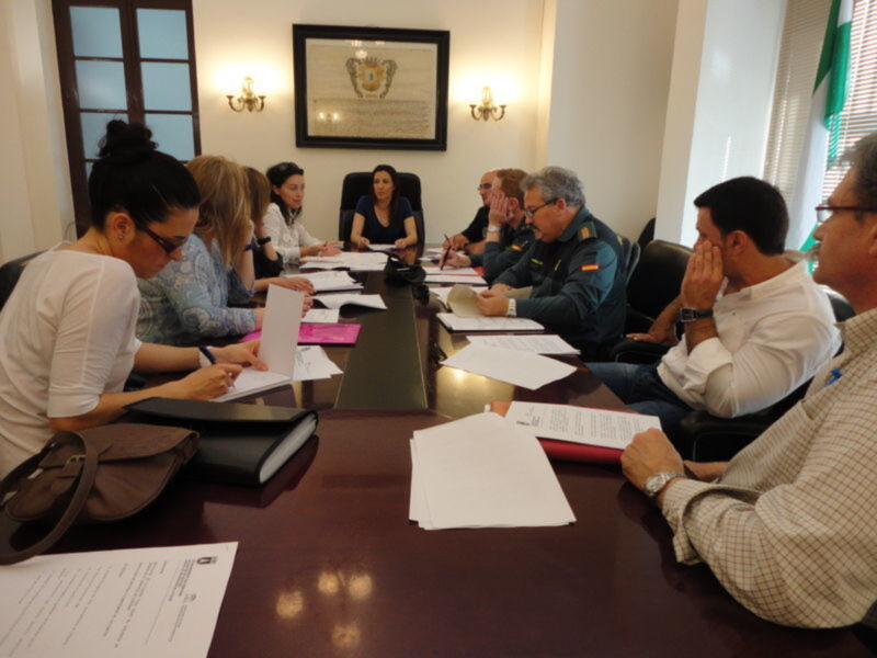 Reunión de trabajo en una oficina formal con documentos y participantes en discusión.