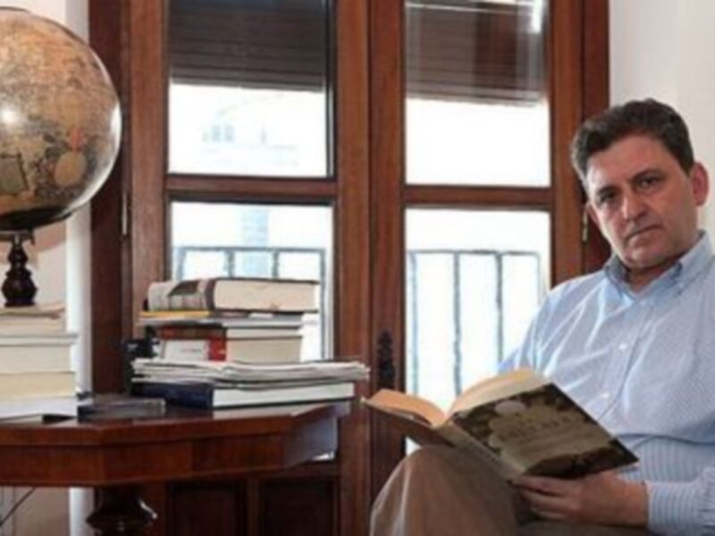 Librero leyendo en un rincón con libros y un globo terráqueo en el fondo.