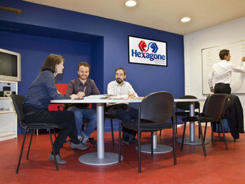 Reunión en un espacio de trabajo profesional con el logo de Hexagone en el fondo.