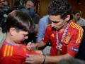 Un joven jugador de fútbol español firma una camiseta para un niño fanático en un evento de la UEFA Euro 2012.