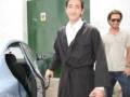 Adrien Brody en ropa de baño, posando junto a un coche.