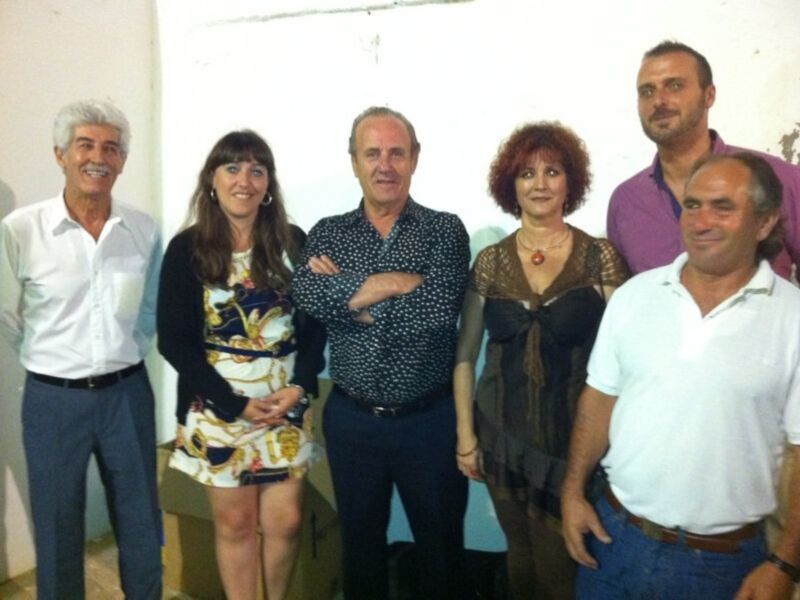 Grupo de personas sonrientes posando juntos en un entorno interior.