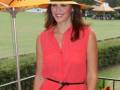 Una mujer con un vestido coral y sombrero amarillo en una feria de golf.
