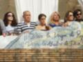 Fotografía de una familia en un balcón con una pancarta que dice '¡¡Dios es la madre de Dios!!'.