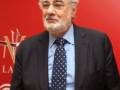Plácido Domingo, famoso tenor español, posa frente a un fondo rojo con el logo de Las Vegas.