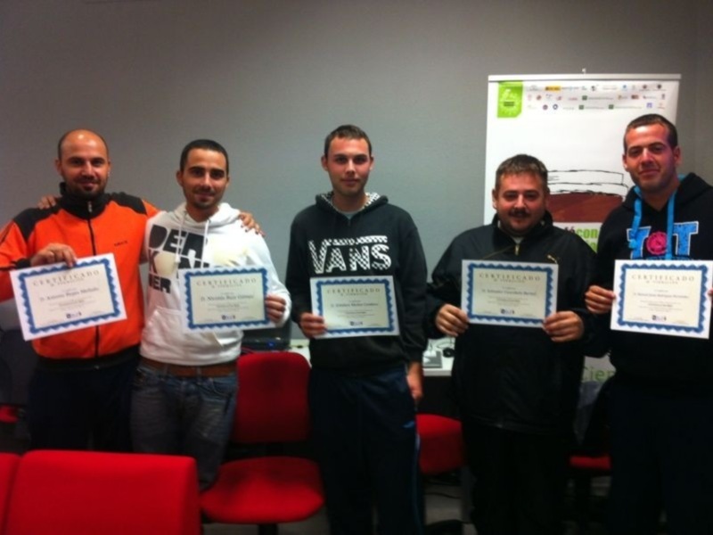 Cuatro personas sonrientes sostienen sus diplomas, celebrando un logro académico o laboral.