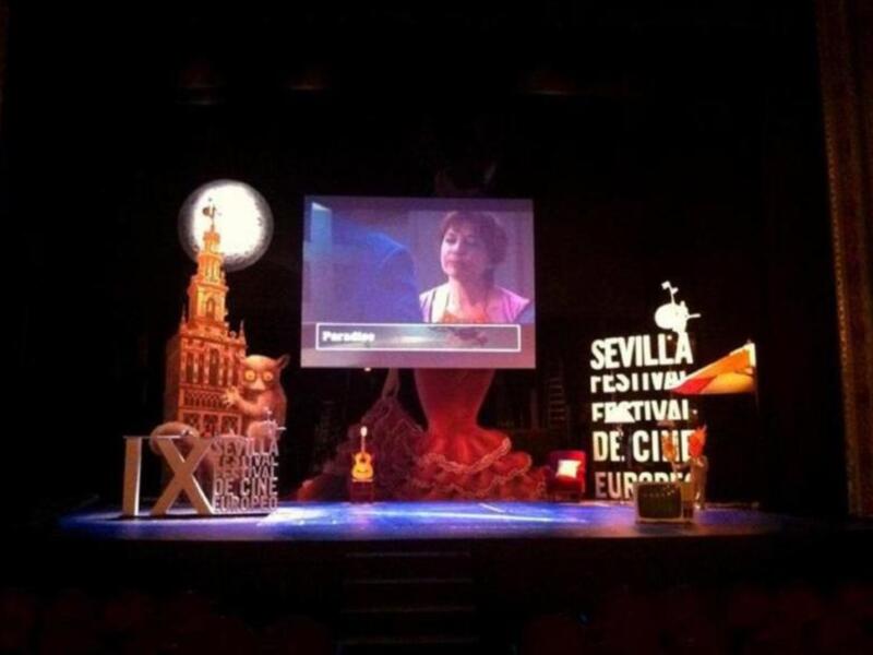 Escenario del Festival de Cine de Sevilla con proyección de película y decoración de flamenco.