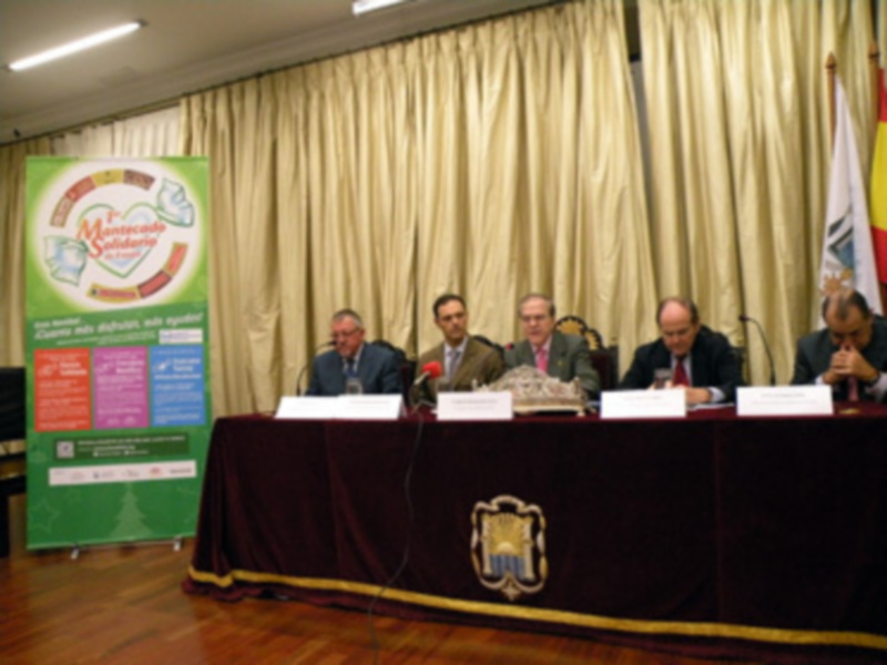 Conferencia de prensa con representantes de instituciones y banderas en el fondo.