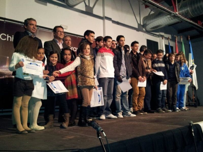 Celebración de logros con jóvenes y adultos en un escenario, recibiendo certificados.