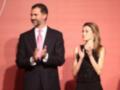 El rey Felipe VI y la reina Letizia de España se encuentran en un evento formal, ambos están claramente sonriendo y saludando al público presente.