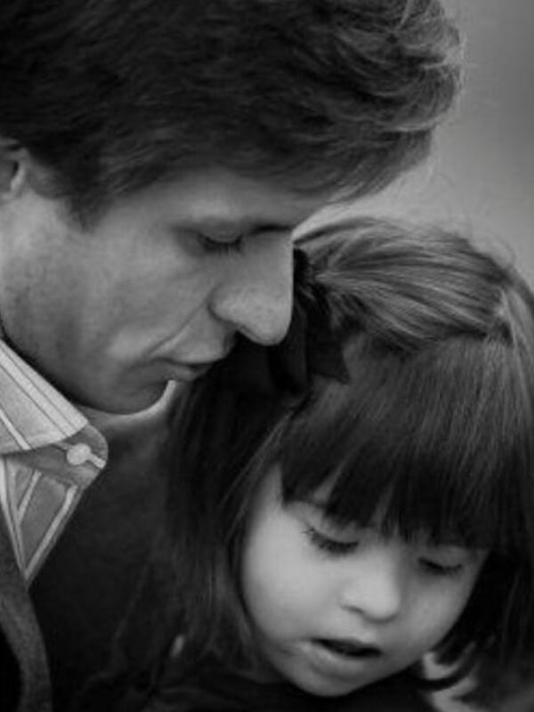 Un padre y su hija comparten un momento íntimo y afectuoso en blanco y negro.
