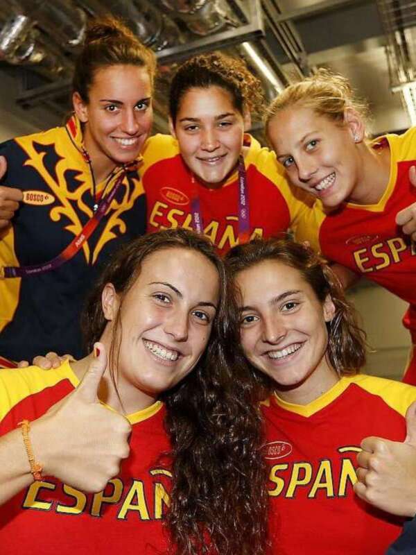 Equipo español celebrando juntos con camisetas de España y gestos positivos.
