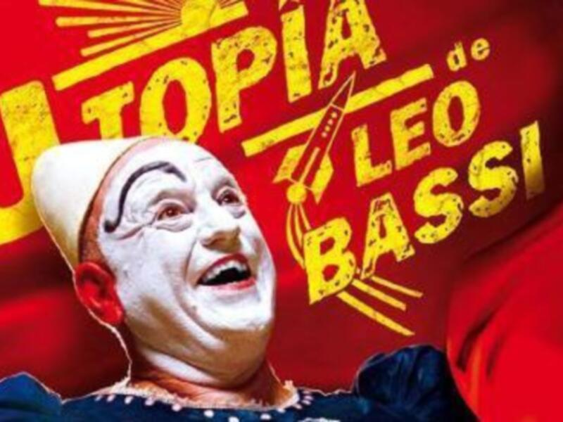 Cartel de la película 'Utopía', con un personaje en máscara y traje de circo en el fondo rojo.