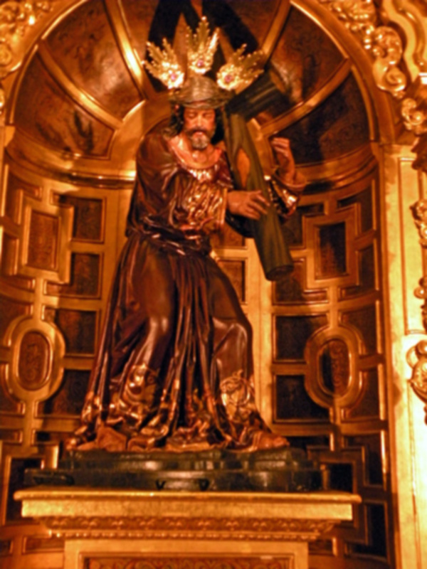 Estatua dorada de San Pedro en un retablo ornado con detalles dorados.