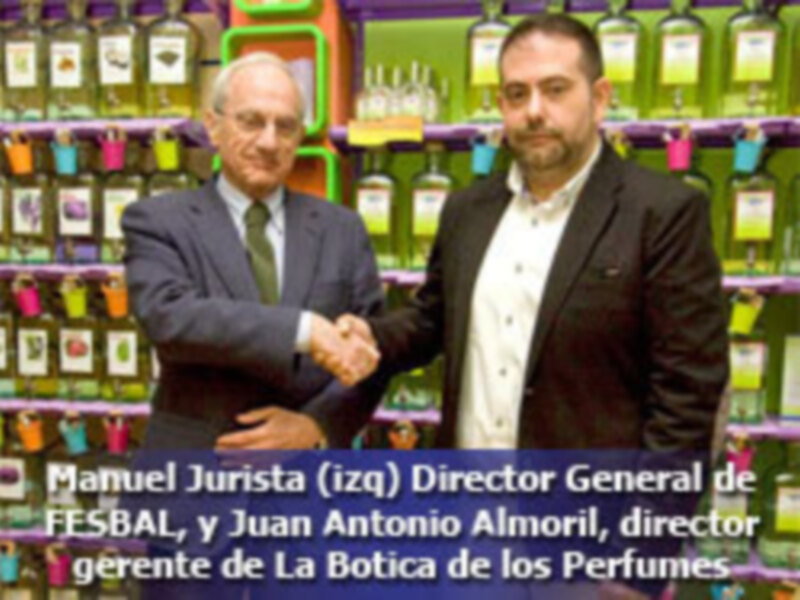 Manuel Jurista, Director General de FFSBAL, y Juan Antonio Aínoril, director gerente de La Bótica de los Perfumes, estrechan la mano en un ambiente de negocios.