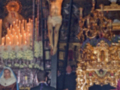 Procesión religiosa con el Cristo de la Buena Muerte en un altar ornado con velas y flores.