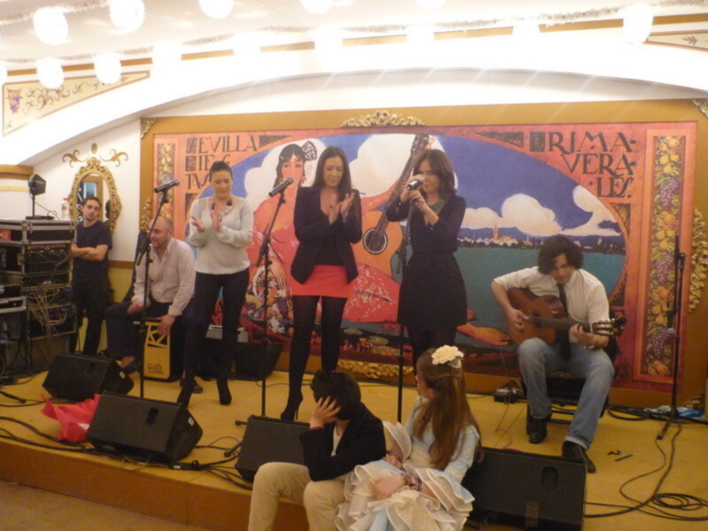 Concierto en Sevilla con música tradicional y artistas locales en escenario decorado.