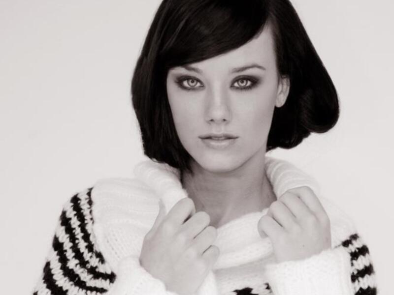 Una mujer con cabello negro corto y una suéter blanco y negro.
