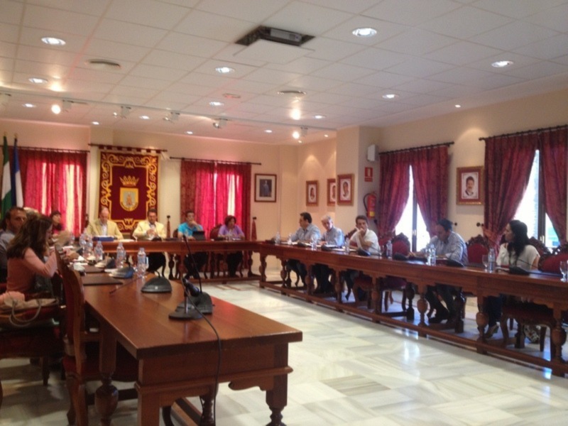 Reunión en sala de reuniones con personas sentadas alrededor de una larga mesa.