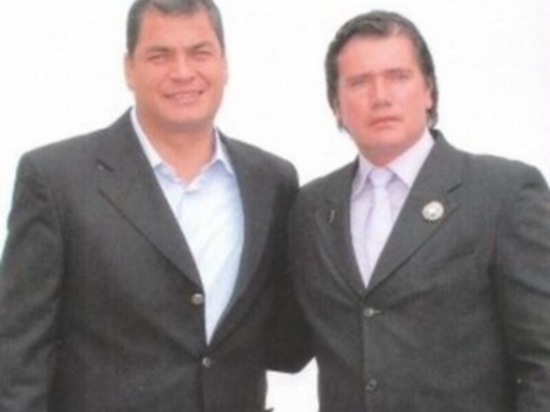Dos hombres en trajes de negocios sonriendo y posando juntos.