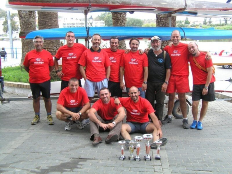 Equipo de remo posando con trofeos en el club de remo Cruzcampo.
