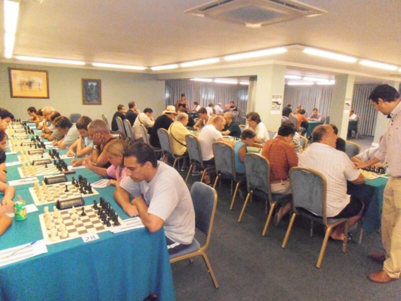 Concentrados en un torneo de ajedrez en un salón bien iluminado.