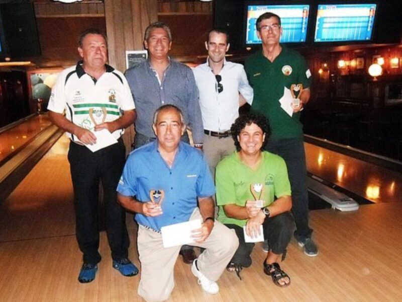 Equipo de bowling con trofeos y diplomas en una alineación de bocce.