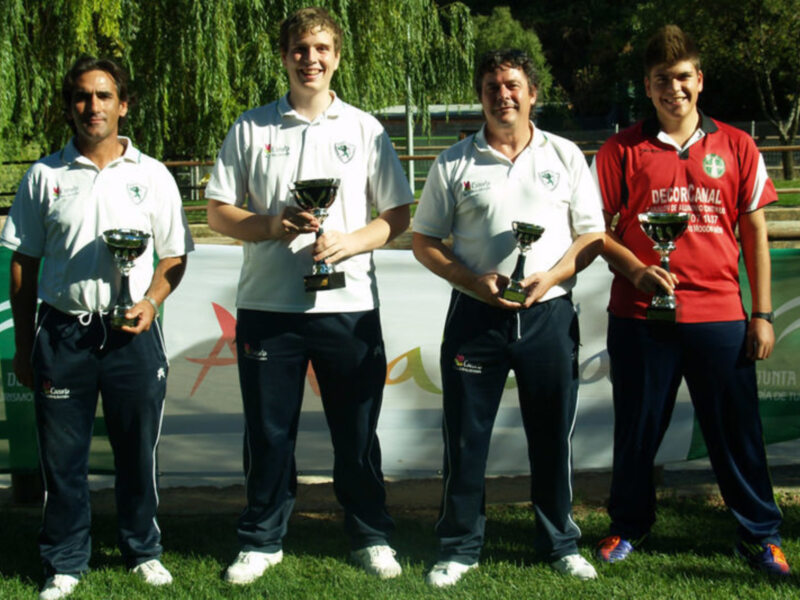 Equipo ganador con trofeos en un evento deportivo al aire libre.