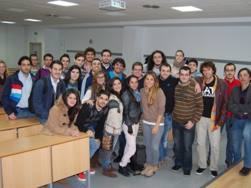 Grupo de estudiantes y profesores posando en un aula universitaria.