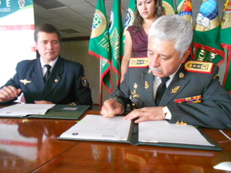 Oficiales militares firmando documentos en una reunión oficial.