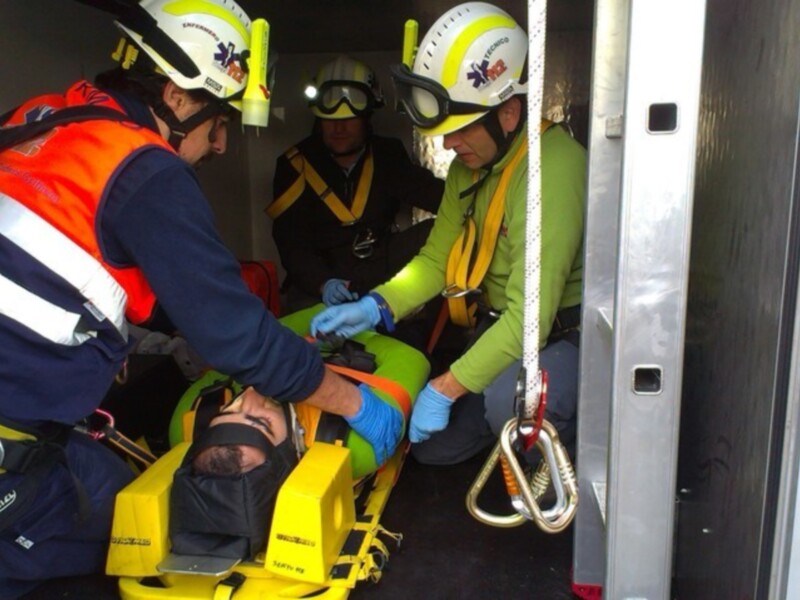 Equipo de rescate en acción, ayudando a un individuo en una silla de ruedas en un entorno de emergencia. Los rescatistas están usando equipos de seguridad y equipo de protección personal.