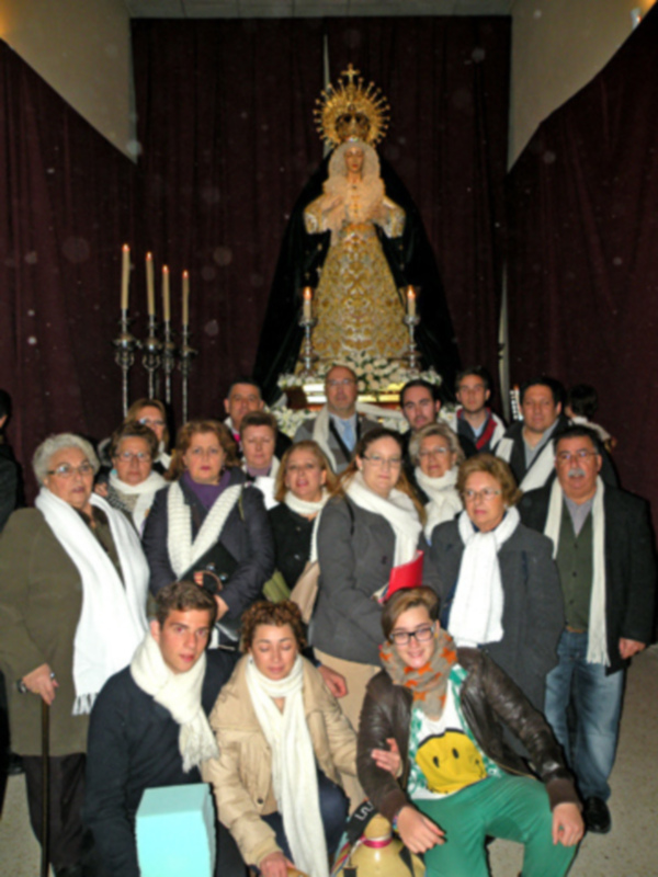 Celebración religiosa con una imagen de la Virgen María y una multitud de personas en un ambiente festivo.