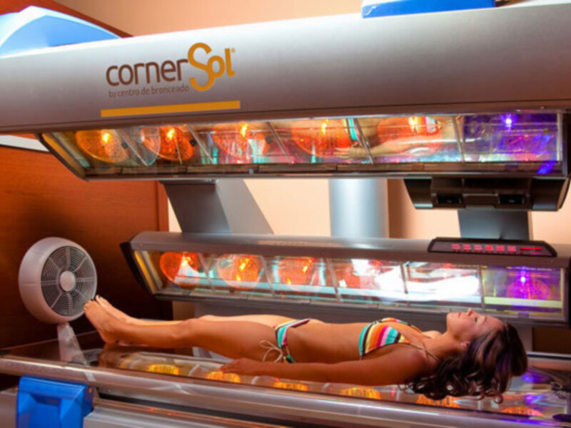 Persona bronceándose en una cabina de bronceado Corner Sol.