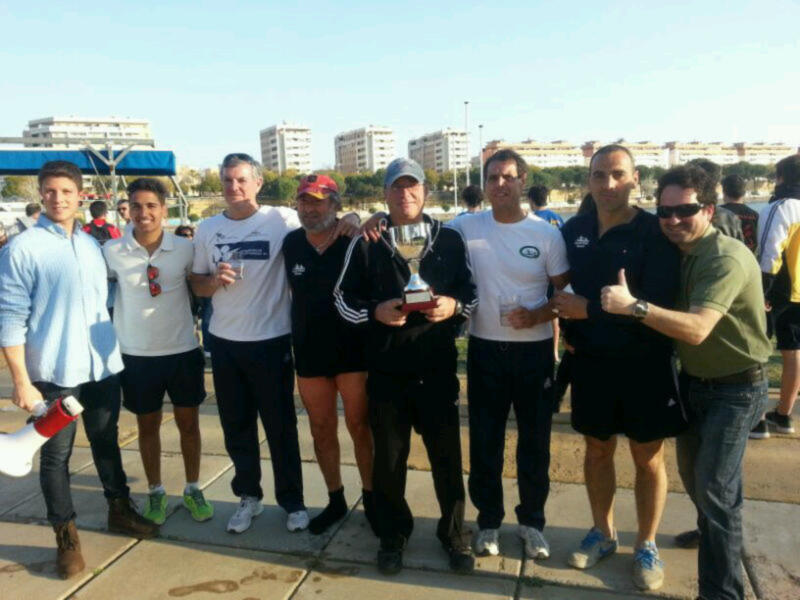 Una escena de una carrera de maratón, con corredores posando para una foto con un trofeo en el centro.