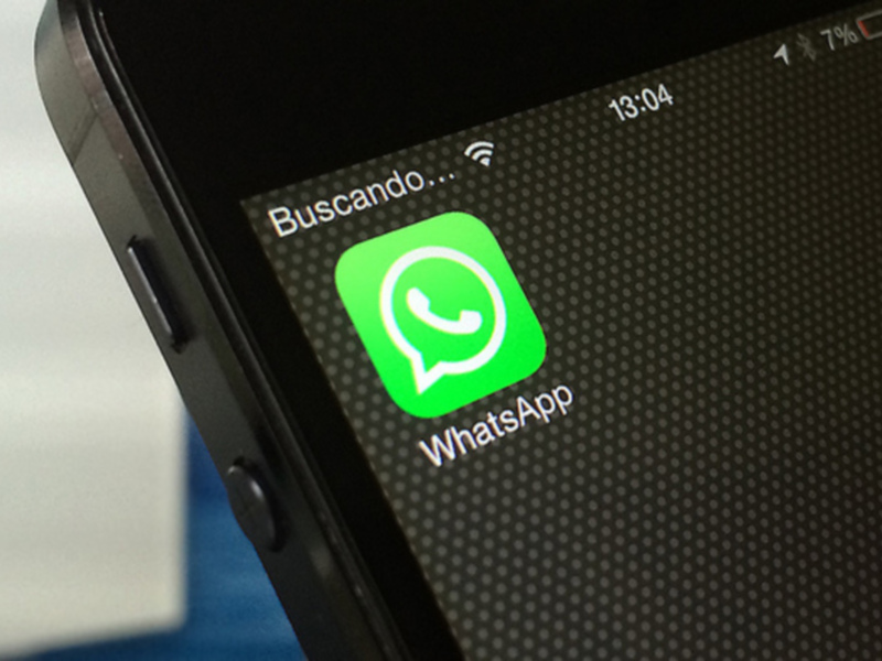 WhatsApp app icon displayed on a smartphone screen with a 'Buscando...' message above it.