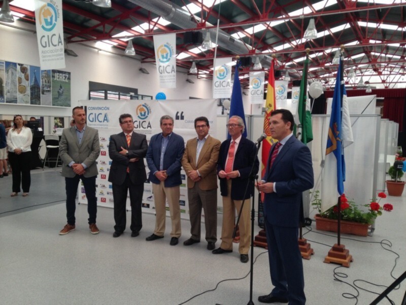 Convención GICA en una sala con banderas y carteles promocionales.