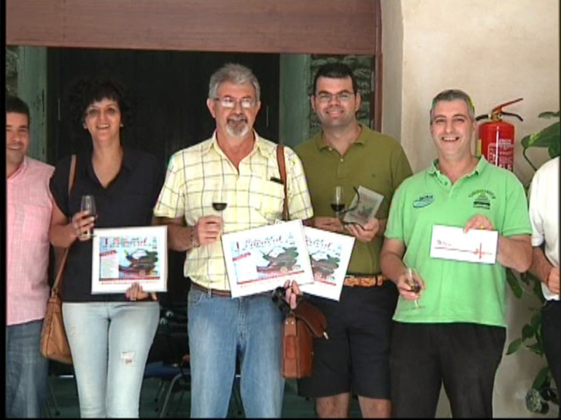 Grupo de personas celebrando con diplomas y vino, posando juntos.