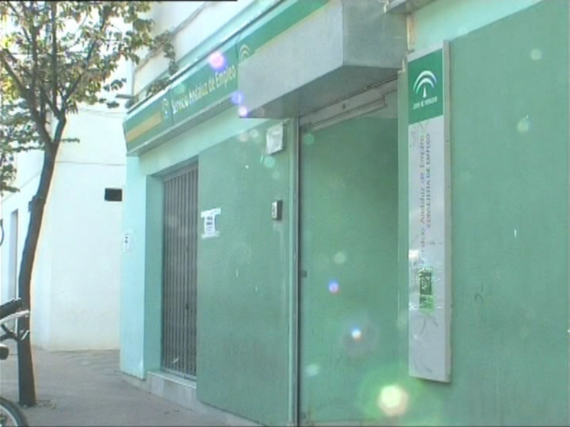 Servicio Andaluz de Empleo, cerrado y con reflejos solares en la fachada verde.