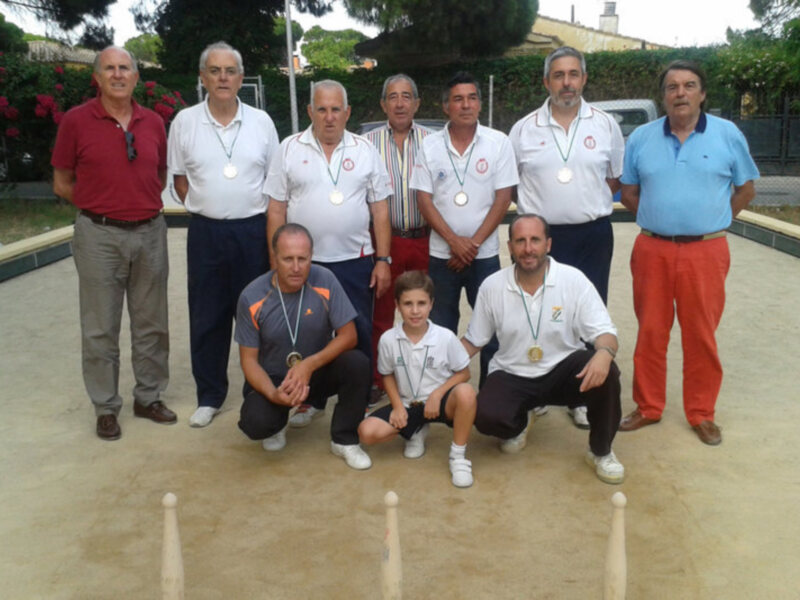 Equipo de boliche con medallas posando en un campo de juego.