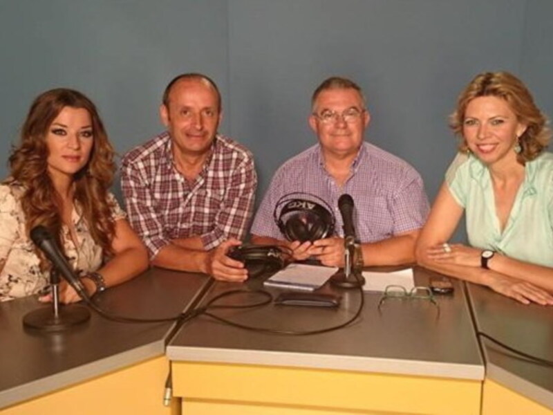 Gruppo di persone in studio radio con microfoni e auricolari.