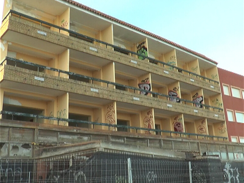 Edificio multiapartamentos con balcones y grafitis en las fachadas.