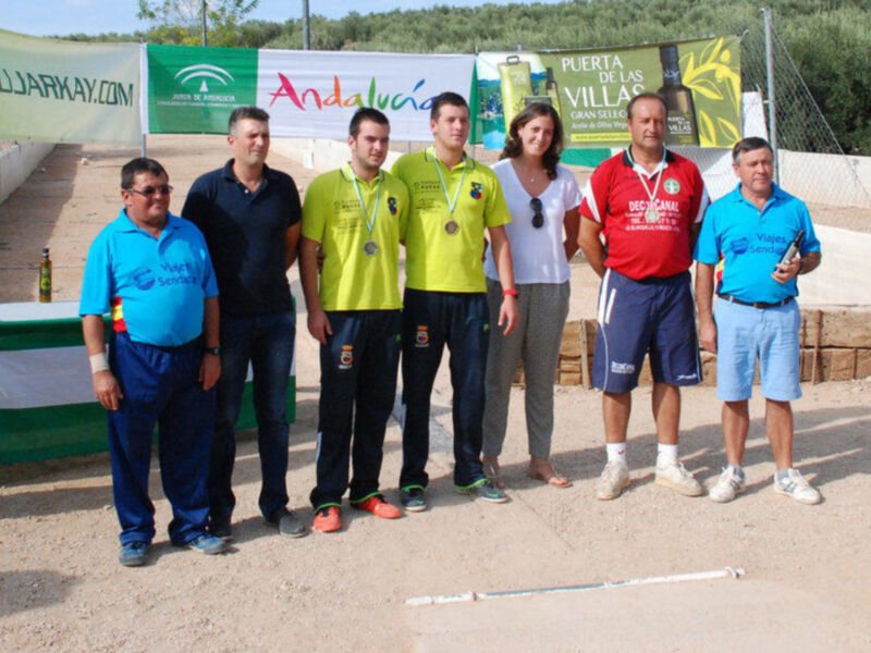 Equipo de atletas con medallas posando en un evento deportivo en Andalucía.