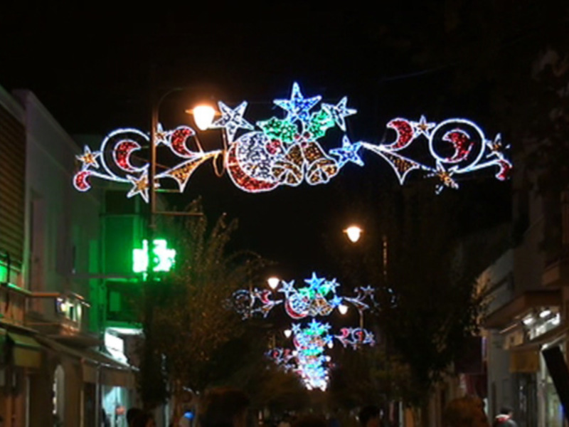 Iluminación navideña en la calle, con estrellas y lunas en colores brillantes.
