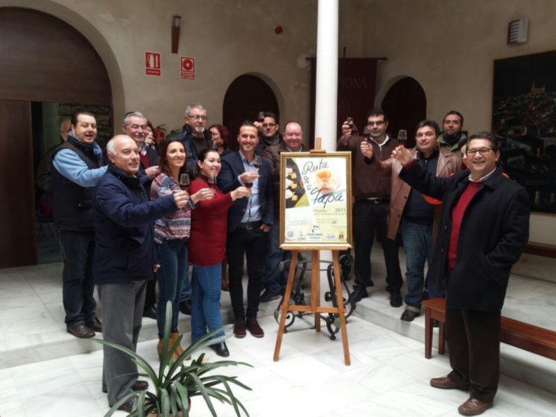 Celebración de la Ruta del Vino Tapas 2015 con un grupo de personas felices y una copa de vino en la mano.