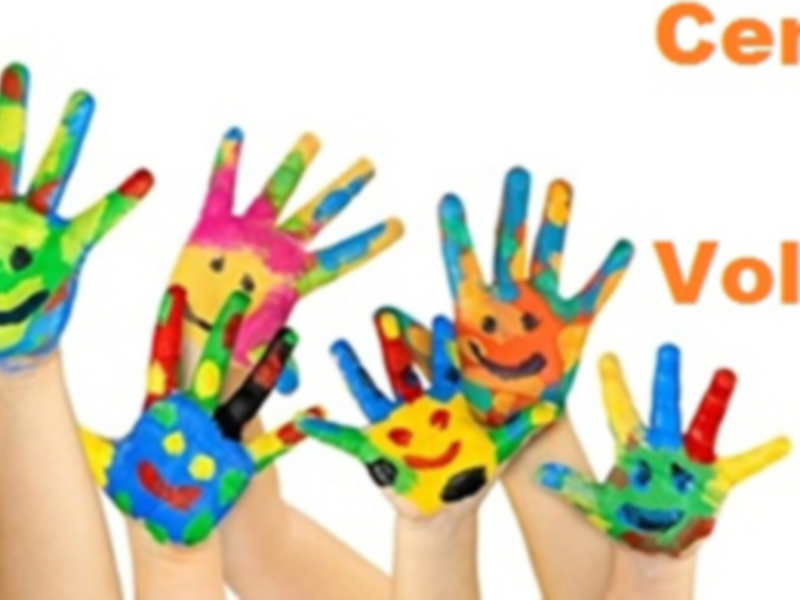 Manos pintadas de colores con caras sonrientes, representando la participación activa y creativa en un centro local de voluntariado.