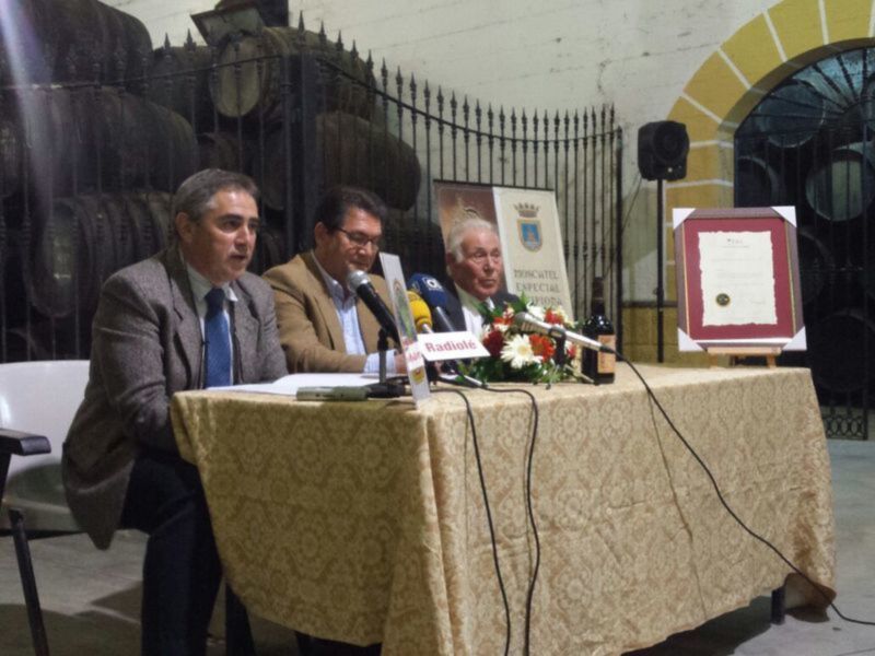 Presentación en bodega con barricas de vino y certificados.