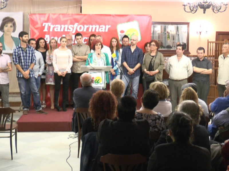 Conferencia pública en un salón con un cartel que dice 'Transformar' y una audiencia atenta.