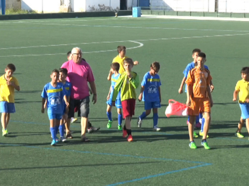 Equipo de fútbol infantil caminando en el campo de juego tras un partido.