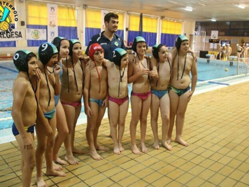 Equipo de waterpolo juvenil posando junto a su entrenador en la piscina del Club Waterpolo Florencia.