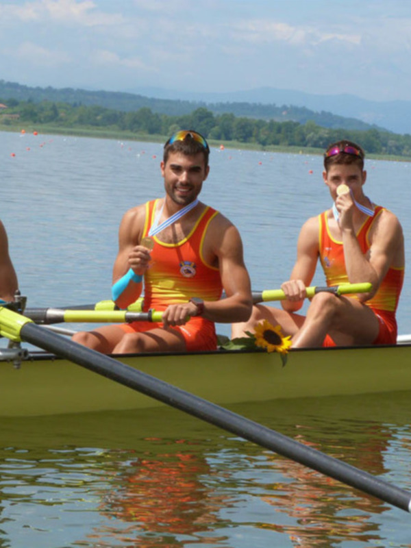 Tres personas en una canoa en un lago, con un horizonte y montañas en el fondo.